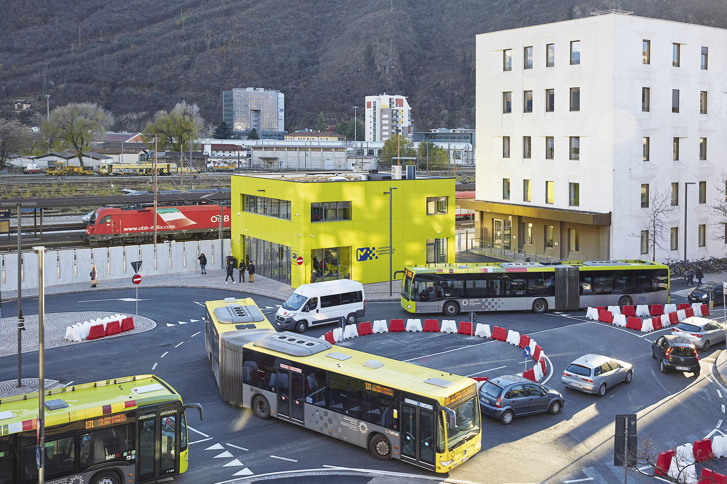 Two busses at a roundabout in front of the Infopoint in Bolzano/Bozen. Aer